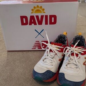 New Balance mens White Sneakers with Red, Blue and Yellow Accents